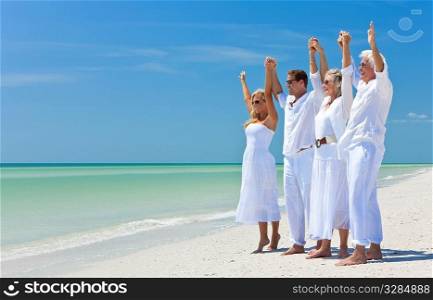 Two couples, generations of a family together holding hands and racing their arms in celebration on a deserted tropical beach