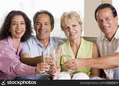 Two couples in living room drinking champagne and smiling