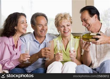 Two couples in living room drinking champagne and smiling