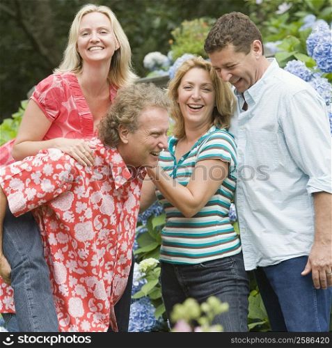Two couples laughing in a park