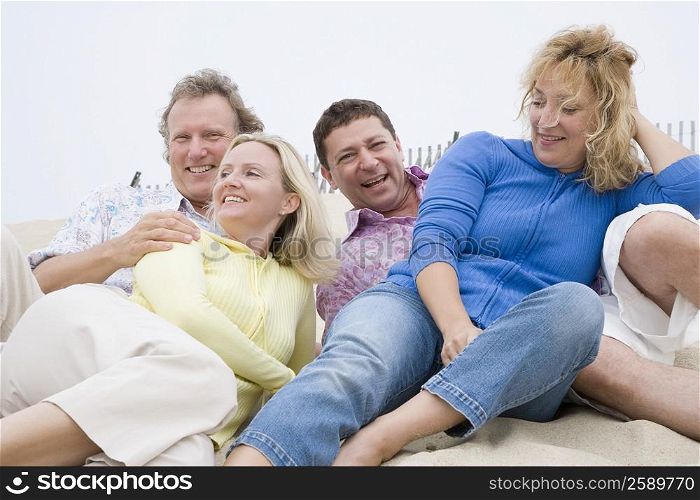 Two couples lying on the beach