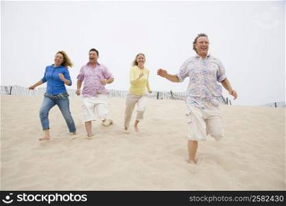 Two couples running on the beach
