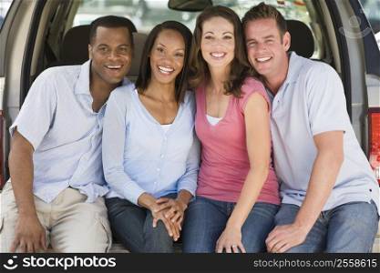 Two couples sitting in back of van smiling