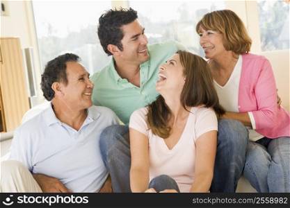 Two couples sitting in living room smiling and laughing