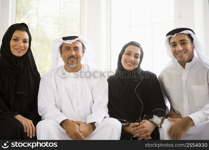 Two couples sitting in living room smiling (high key/selective focus)