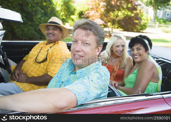 Two couples sitting on a convertible car