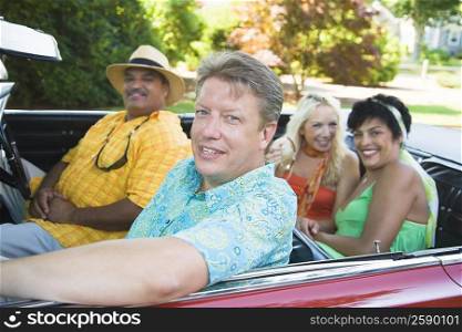 Two couples sitting on a convertible car