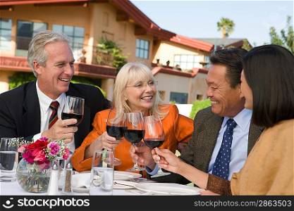 Two couples toasting outdoors