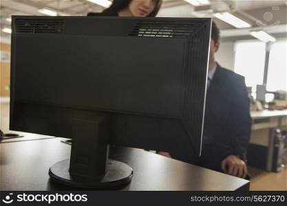 Two coworkers looking at computer monitor