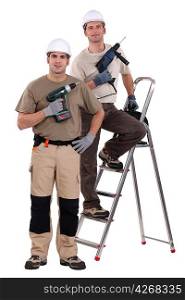 two craftsmen holding drills