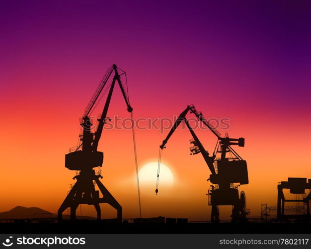 Two cranes sit dramatically against a colorful sunset in a large shipyard