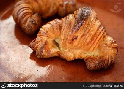 Two croissant pastries over orange clay
