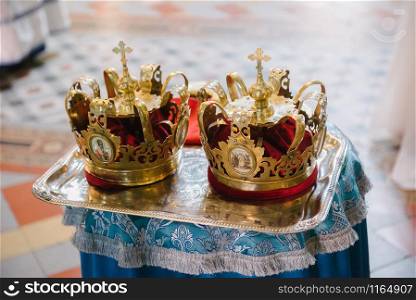 Two crowns for weddings on a tray in a church close up. Two wedding crowns in church close up