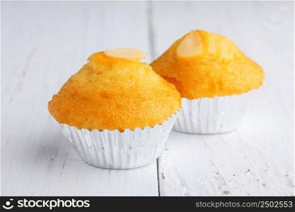 Two cupcakes with almond on wooden table