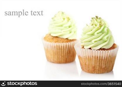 two cupcakes with green cream isolated on white background with copyspace