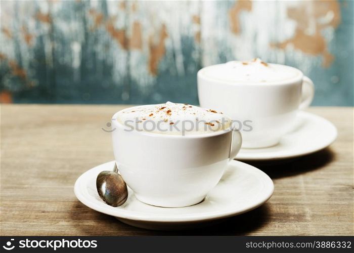 Two cups of coffee on old wooden table