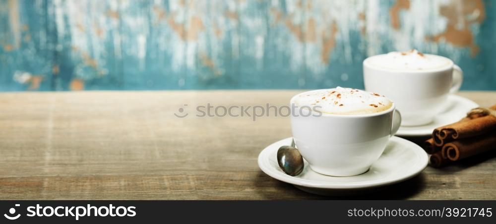 Two cups of coffee on old wooden table