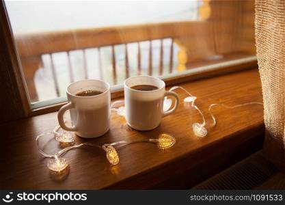 two cups of coffee on the windowsill in a wooden house in the Carpathians.. two cups of coffee on the windowsill in a wooden house in the Carpathians