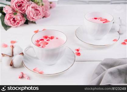 Two cups of pink matcha. Relaxing drink to improve sleep. Trendy vegan tea on a white background.. Two cups of pink matcha. Relaxing drink to improve sleep. Trendy vegan tea on white background.