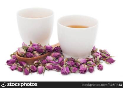 Two cups of rose tea with dried rose flower on white background