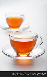 two cups of tea over white background
