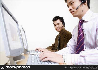 Two customer service representatives working on a computer