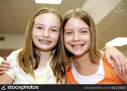Two cute adolescent girls together in school.