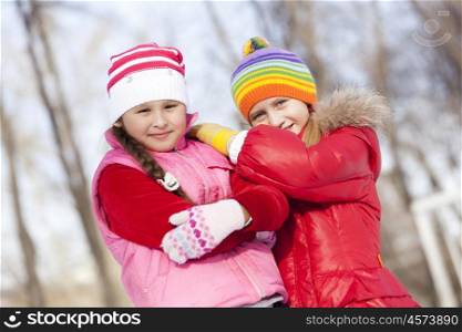 Two cute girls having fun in winter park. Winter activities