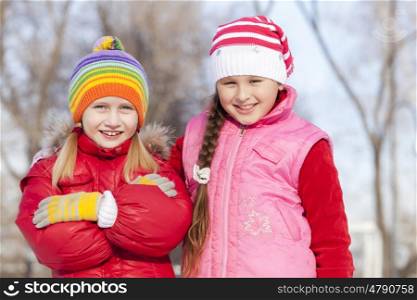 Two cute girls having fun in winter park. Winter activities