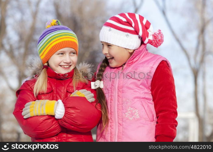 Two cute girls having fun in winter park. Winter activities