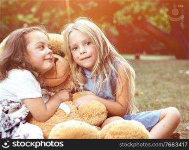 Two cute girls hugging a huge, new teddy bear