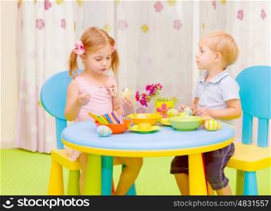 Two cute kids painted traditional Easter symbol, having fun at home, elementary school, art lesson concept