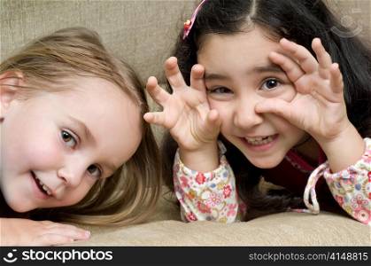 two cute little girls lying on the sofa. two cute little girls