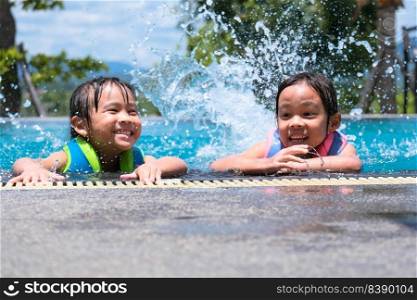 Two cute little girls playing in the pool. Summer lifestyle concept.