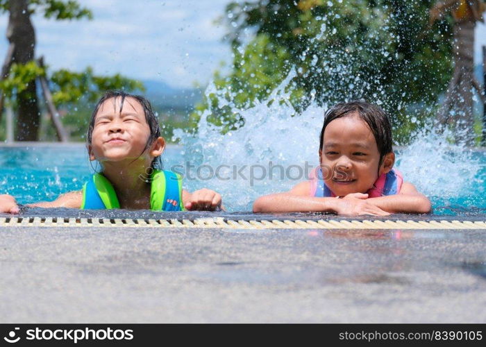 Two cute little girls playing in the pool. Summer lifestyle concept.