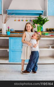 Two cute little kids with easter eggs having fun in the kitchen. Happy easter.. Two cute little kids with easter eggs having fun in the kitchen.