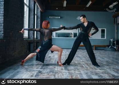 Two dancers in costumes on ballrom dance training in class. Female and male partners on professional pair dancing in studio. Two dancers in costumes on ballrom dance training