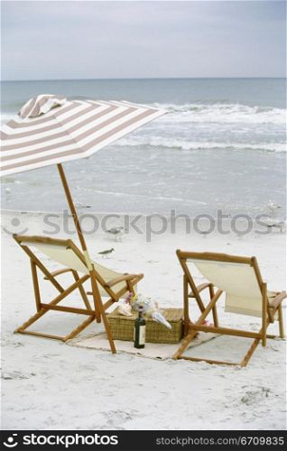 Two deck chairs and an umbrella on the beach