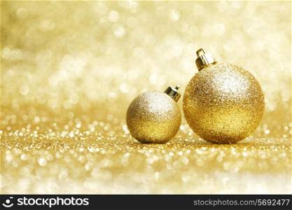 Two decorative christmas balls on golden background