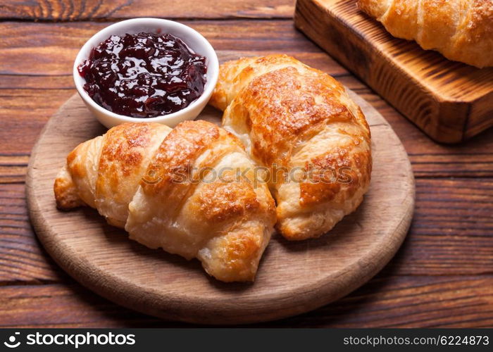 Two delicious croissants on a wooden cutting board. Breakfast with fresh croissants