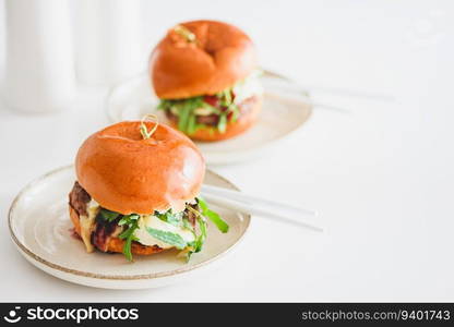 Two delicious homemade burgers with beef, cheese and vegetables on white wooden table