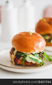 Two delicious homemade burgers with beef, cheese and vegetables on white wooden table