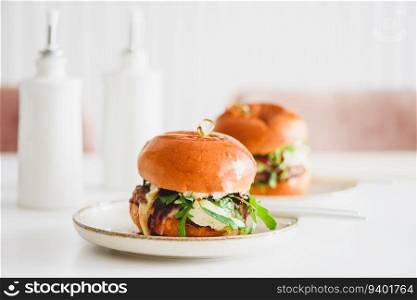 Two delicious homemade burgers with beef, cheese and vegetables on white wooden table