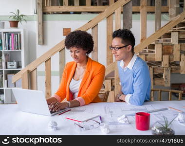 Two desingers working on a project together in office. Creative team at work