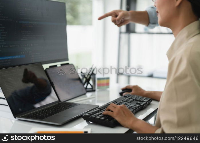 Two developer programmer checking code on multiple monitor while programming to developing website.