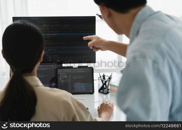 Two developer programmer checking code on multiple monitor while programming to developing website.