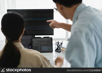 Two developer programmer checking code on multiple monitor while programming to developing website.