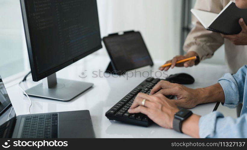 Two developer programmer typing code while discussing about programming to developing website.