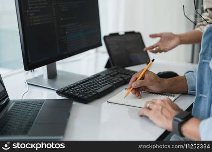 Two developer programmer writing notes while discussing about programming to developing website.