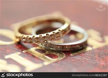 Two diamond wedding bands for a double bride wedding on the cover of the bible
